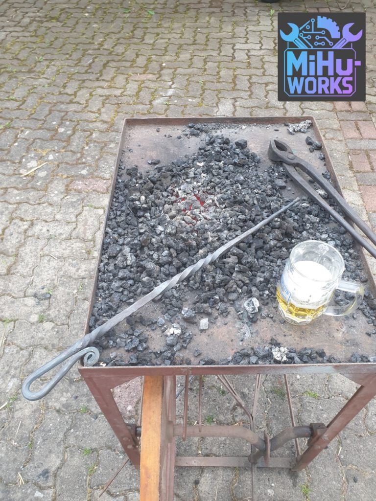 Selbst geschmiedeter Bierstachel neben einem Glas Bier