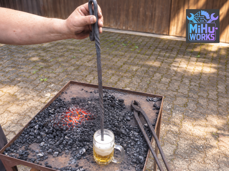 Selbst geschmiedeter Bierstachel wird in ein Glas Bier getaucht